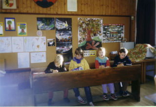 Kinder sitzen auf der alten Schulbank
